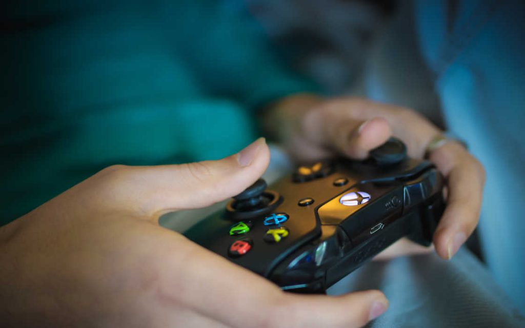 An Xbox controller in the hands of a player.